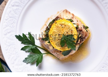 Healthy Food concept Homemade Lemon garlic butter Baked Cod fish on black background with copy space