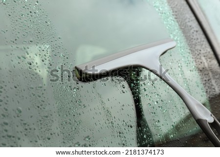 Wiping car window with drying blade outdoors, closeup Royalty-Free Stock Photo #2181374173