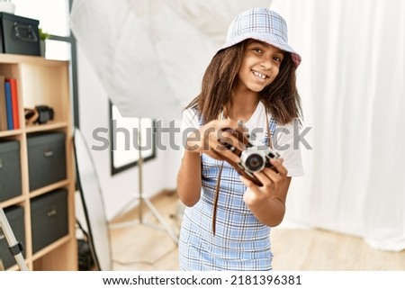 African american girl smiling confident using camera at photography studio