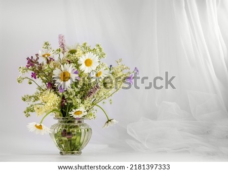 A bouquet of wildflowers on a light background. Copy space for text. Royalty-Free Stock Photo #2181397333