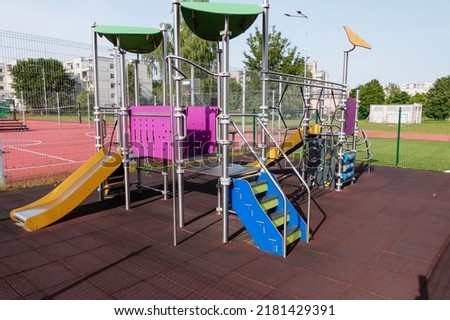 Colorful children playground near sports field stadium in the city Royalty-Free Stock Photo #2181429391
