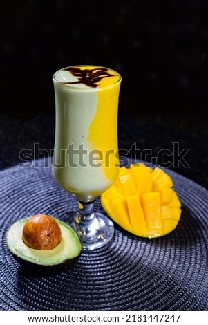 avocado and mango shake served in a dish isolated on dark background side view