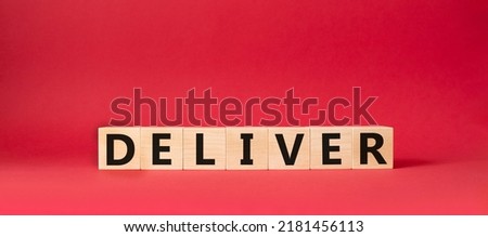 Deliver symbol. Concept word Deliver on wooden cubes. Beautiful red background. Business and Deliver concept. Copy space.