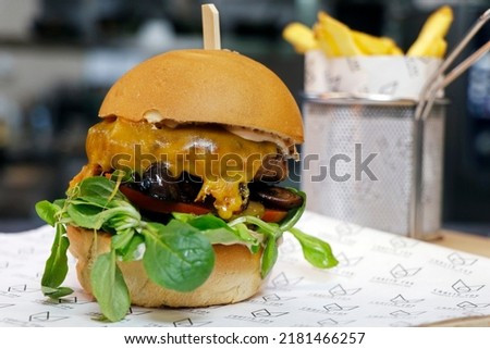 angus beef burger with mushroom, cheese, tomatoes and lettuce in close up