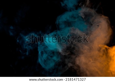 movement of a cloud of cigarette vapour in different colours degrading from orange to blue, on dark background. banner with illuminated coloured smoke.