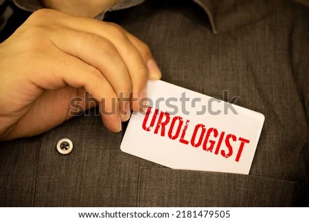 Word UROLOGY. Urology text on wooden blocks. In front of a row of cubes are ampoules, in the background - white plastic packaging from tablets, the cubes are located on a gray surface.