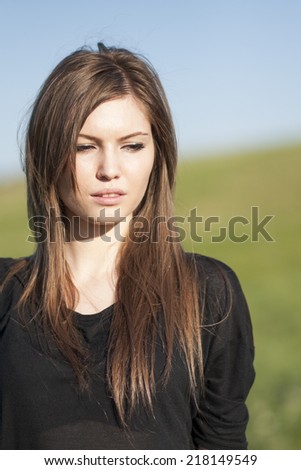 Beautiful girl with long, straight hair posing in the field 