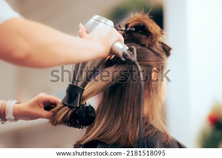 

Woman Having her Hair Straighten with a Brush and a Hair Dryer. Hairdresser drying clients hair working with professional tools
 Royalty-Free Stock Photo #2181518095