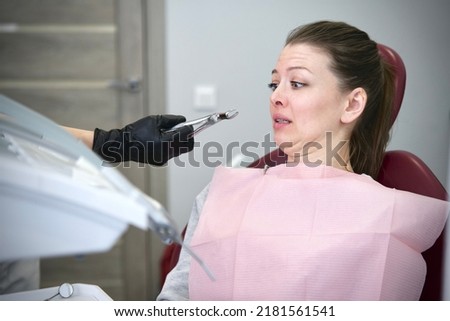 Portrait of scared horrified frightened  girl patient with dentist phobia, young woman in panic is crying afraid of stomatologist, sitting at dentistry office in armchair. Fear of doctor, pain Royalty-Free Stock Photo #2181561541