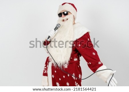 Holidays and christmas concept. Santa Claus sings with a microphone in his hand. Isolated on white