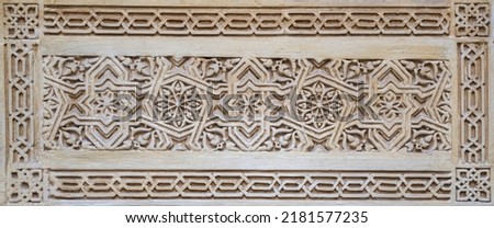 Tiles with bas-relief of Arabic and Mudejar style on a wall of the Alcaicería of Granada, Spain Royalty-Free Stock Photo #2181577235
