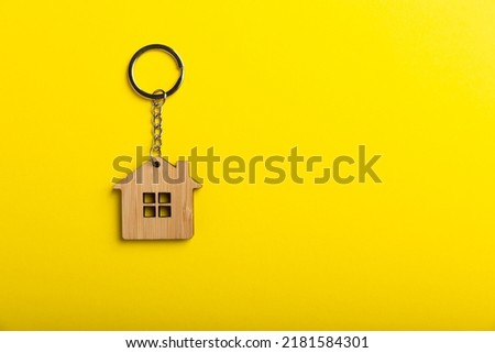House model and keys on yellow background, flat lay. Housewarming. Real estate investment concept. planning to save money to buy a house. Mortgage and real estate investment, savings for home.