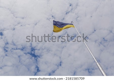 view on Ukrainian flag on flagpole against cloudy sky