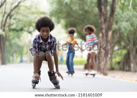 Boy playing on roller blades. African American boy riding roller blades in the road. Kid practicing roller blades.