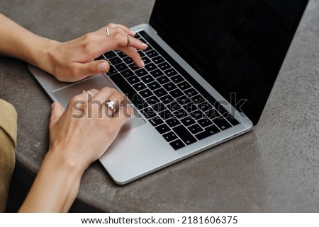 young woman working using laptop, woman's hands, close up. High quality photo, horizontal