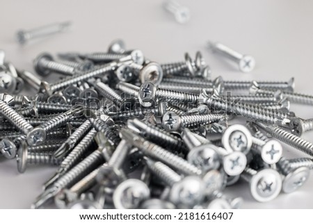 Tapping screws made of steel on Gray background, metal screw, iron screw, chrome screw, screws as a background, wood screw, concept industry. copy space for text. Royalty-Free Stock Photo #2181616407