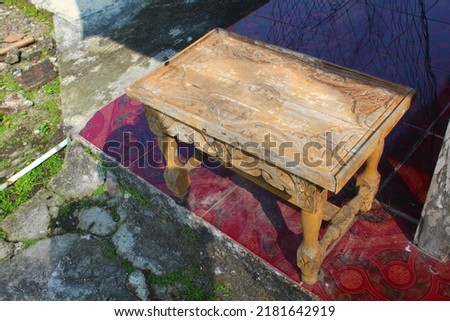 original photo, a small old rectangular Javanese table with carvings, creative shooting style.