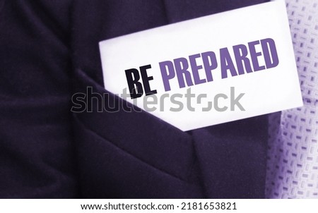 Businessman with a card with text Be Prepared in upper suit pocket.