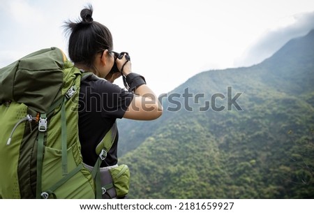 Woman photographer taking pictures in spring mountain