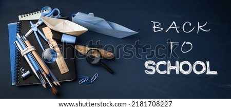 Back to school banner, concept background with lettering on dark blue chalkboard. School supplies on chalkboard background.