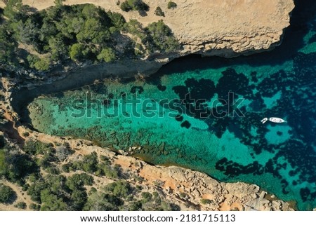 Aerial drone top down photo of boat anchored in exotic island covered with pine trees