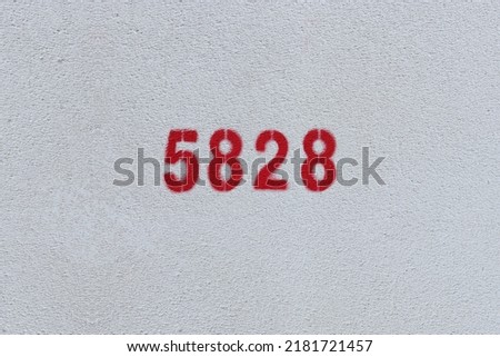 Red Number 5828 on the white wall. Spray paint.
