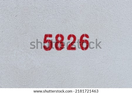 Red Number 5826 on the white wall. Spray paint.
