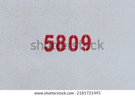 Red Number 5809 on the white wall. Spray paint.
