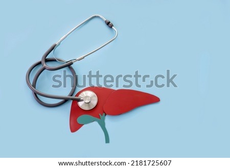 model of a human liver made of paper and a stethoscope on a blue background. concept timely diagnosis of liver diseases Royalty-Free Stock Photo #2181725607