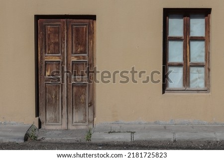 Wooden door and wooden framed glass, background cream wall.