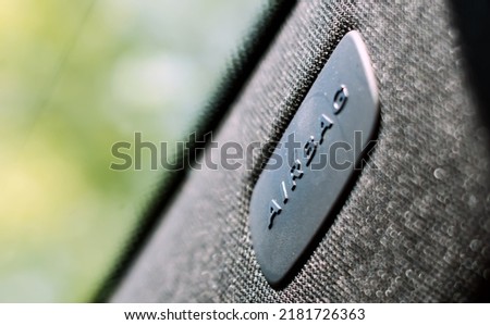 The embossed Airbag logo on a plastic plate on the windshield pillar of a modern car. The airbag is a passive safety device installed in cars to protect passengers from collisions Royalty-Free Stock Photo #2181726363