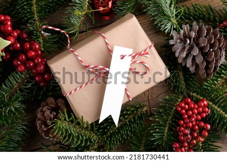 Christmas rectangle strip gift tag mockup with present box, product label mockup, with natural fir tree branch, cones and Christmas decoration, Christmas sale concept. Blank paper rectangular name tag