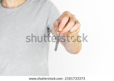 a man in a gray t-shirt gives a key