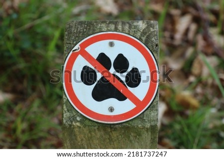 Graphic sign with a red line though a paw meaning that dogs are not allowed past this point Royalty-Free Stock Photo #2181737247