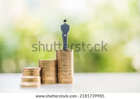 Businessman is introducing the investment saving money with stack gold coin with looking to future for new the opportunity in the public park, Loan for business concept. Royalty-Free Stock Photo #2181739985