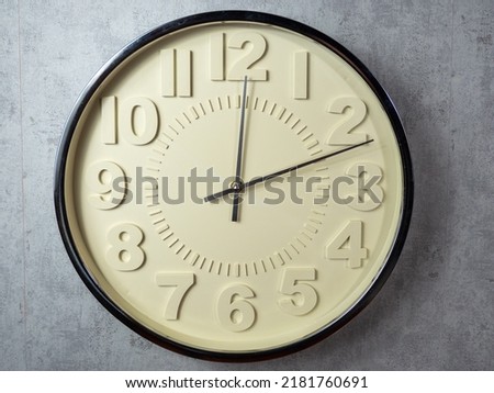 Wall clock on a gray background. Clock close-up. Watch face with large numbers. Royalty-Free Stock Photo #2181760691