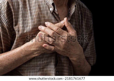 Asian elder man suffering from central chest pain. Chest pain can be caused by heart attack, myocardial infarct or ischemia, myocarditis, pneumonia, oesophagitis, stress, etc,. Royalty-Free Stock Photo #2181761677