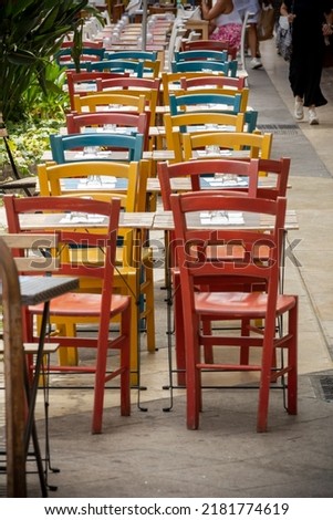 Clolored Wooden Chairs on Sidewalk in the City of Cagliari, in the Region of Sardinia, Italy, in Summer on Blurred Background