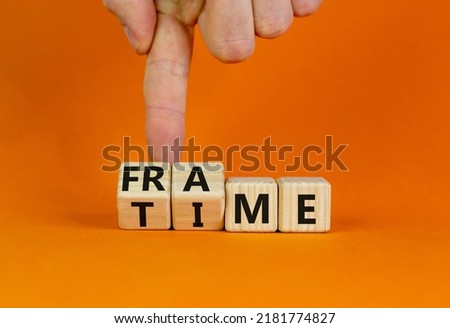 Time frame symbol. Businessman turns wooden cubes and change the concept word time to frame. Beautiful orange table, orange background, copy space. Business and time frame concept.