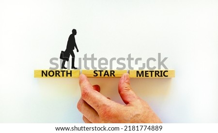 North star metric symbol. Concept words North star metric on wooden blocks on a beautiful white table white background. Businessman hand. Business finacial and north star metric concept. Copy space.