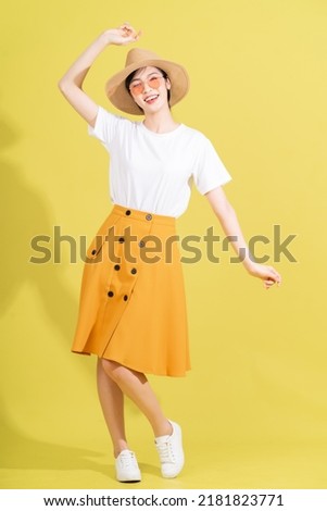 Full length photo of young Asian girl on yellow background
