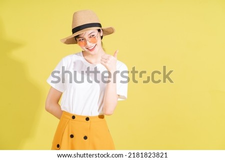Portrait of young Asian girl on yellow background