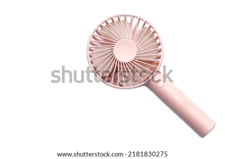 Mini electric pink fan with handle, isolated on white background. Concept : Portable electrical equipment that very useful when hot weather.                      Royalty-Free Stock Photo #2181830275