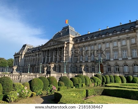 Front facade of The Royal Palace of Brussels. It is  is the official palace of the Belgian Royal family in the city centre. Belgian flag is waiving on top of the building. Bruxelles, Belgium