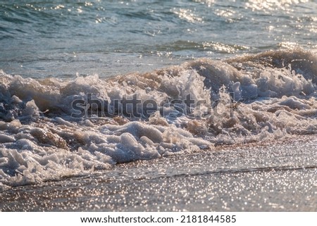 Splashes of water and foam against the sea on a sunny summer day. Copy space background