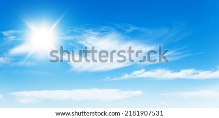 Sunny day background, blue sky with white cumulus clouds and sun, natural summer or spring background with perfect hot day weather. Royalty-Free Stock Photo #2181907531