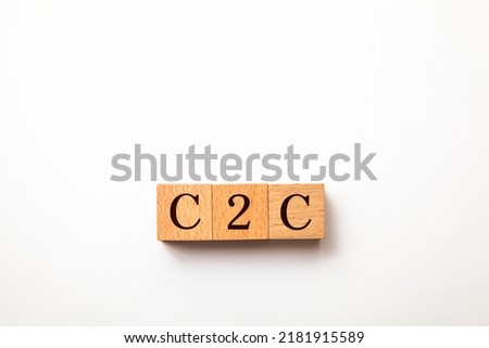 Transactions between individuals. C2C. Consumer to Consumer. B2C letters drawn on a wooden block. Wooden table background.