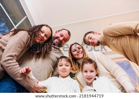 View from bottom of happy large caucasian family with many children making selfie photo at home, parents with kids looking at camera and having fun while taking selfie picture together