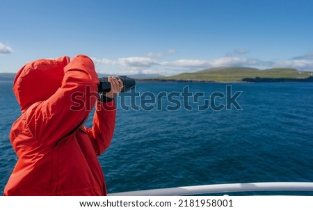 Travel photographer shooting in Faroe Islands. Scenic cruising inside passage cruise tourist vacation adventure. Woman taking photo picture.