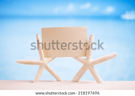 white starfish with blank retro photo on white sand beach, sky and seascape, shallow dof